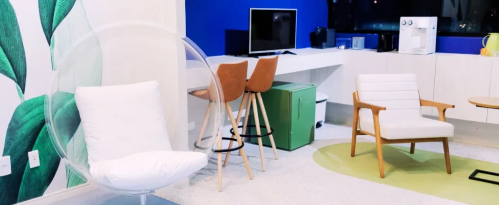 Interior moderno de um espaço de coworking médico, com cadeiras confortáveis, mesa de trabalho e decoração acolhedora.