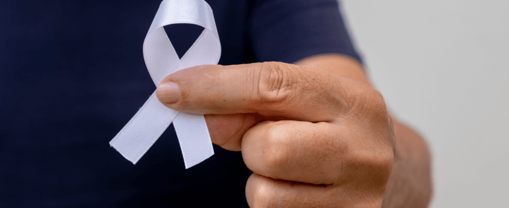 Laço branco segurado por uma mão, representando a campanha Janeiro Branco pela conscientização da saúde mental.
