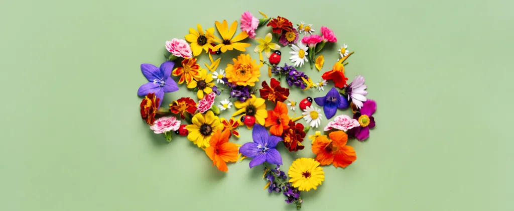 Representação artística de mente saudável e autocuidado com flores em formato de cérebro.