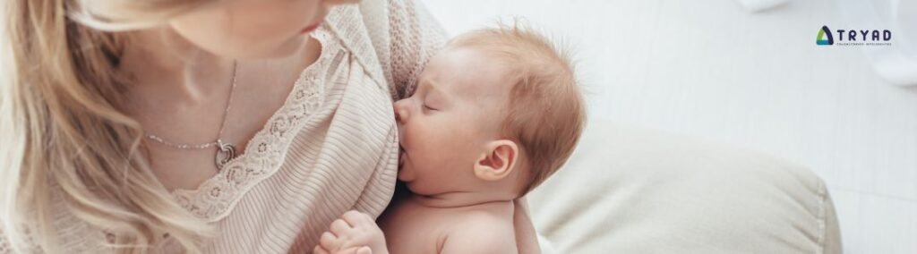 Mãe amamentando seu bebê no colo, simbolizando o vínculo e a importância do aleitamento materno.